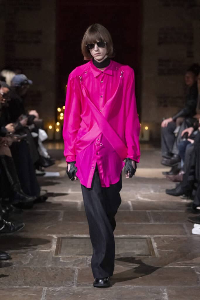 Model in a bright fuchsia oversized shirt with draped detailing by John Richmond