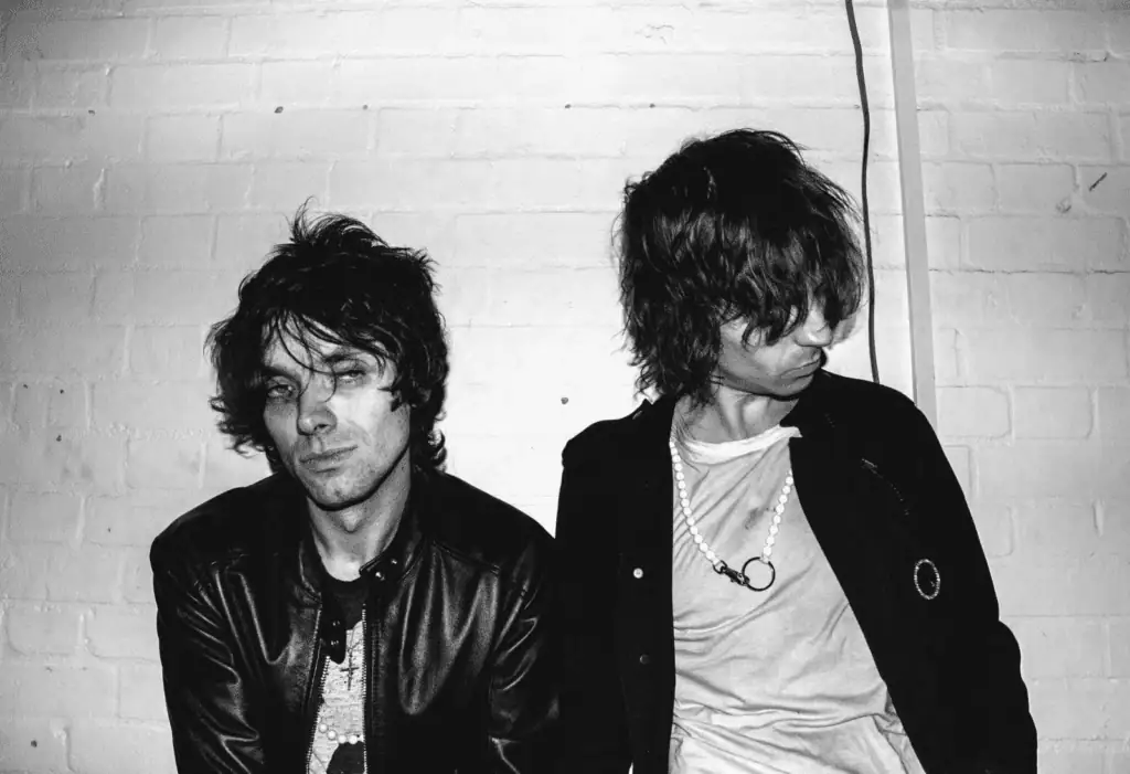 Close-up black and white photo of The Hellp band members looking away from the camera, featuring messy hair and alternative streetwear.