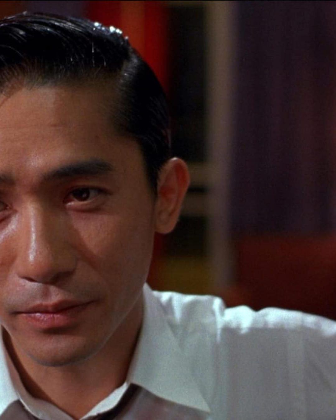 Tony Leung’s character in a close-up scene from “In the Mood for Love,” expressing restrained emotion.