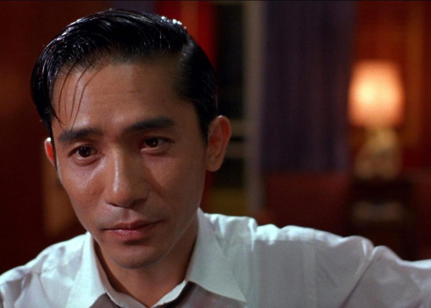 Tony Leung’s character in a close-up scene from “In the Mood for Love,” expressing restrained emotion.